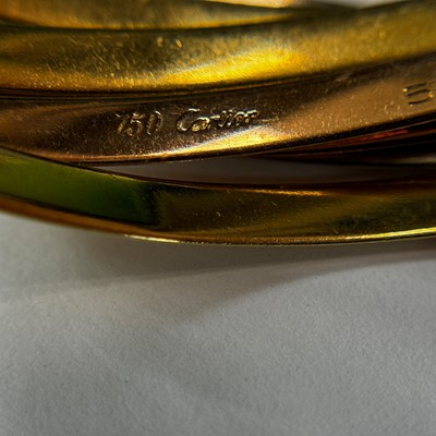 Lot 51 - Cartier Tricolor Gold Seven Band 'Trinity' Rolling Bangle Bracelet, France