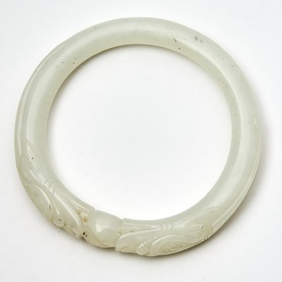 Lot 523 - A Chinese White Jade 'Dragon' Bangle