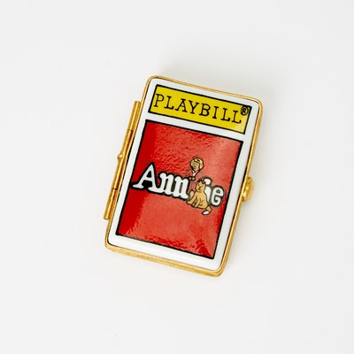 Lot 31 - A porcelain box in the shape of an Annie playbill