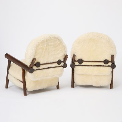 Lot 236 - Pair of After Charlotte Perrriand Sheepskin Upholstered Stained Beechwood Chalet Armchairs